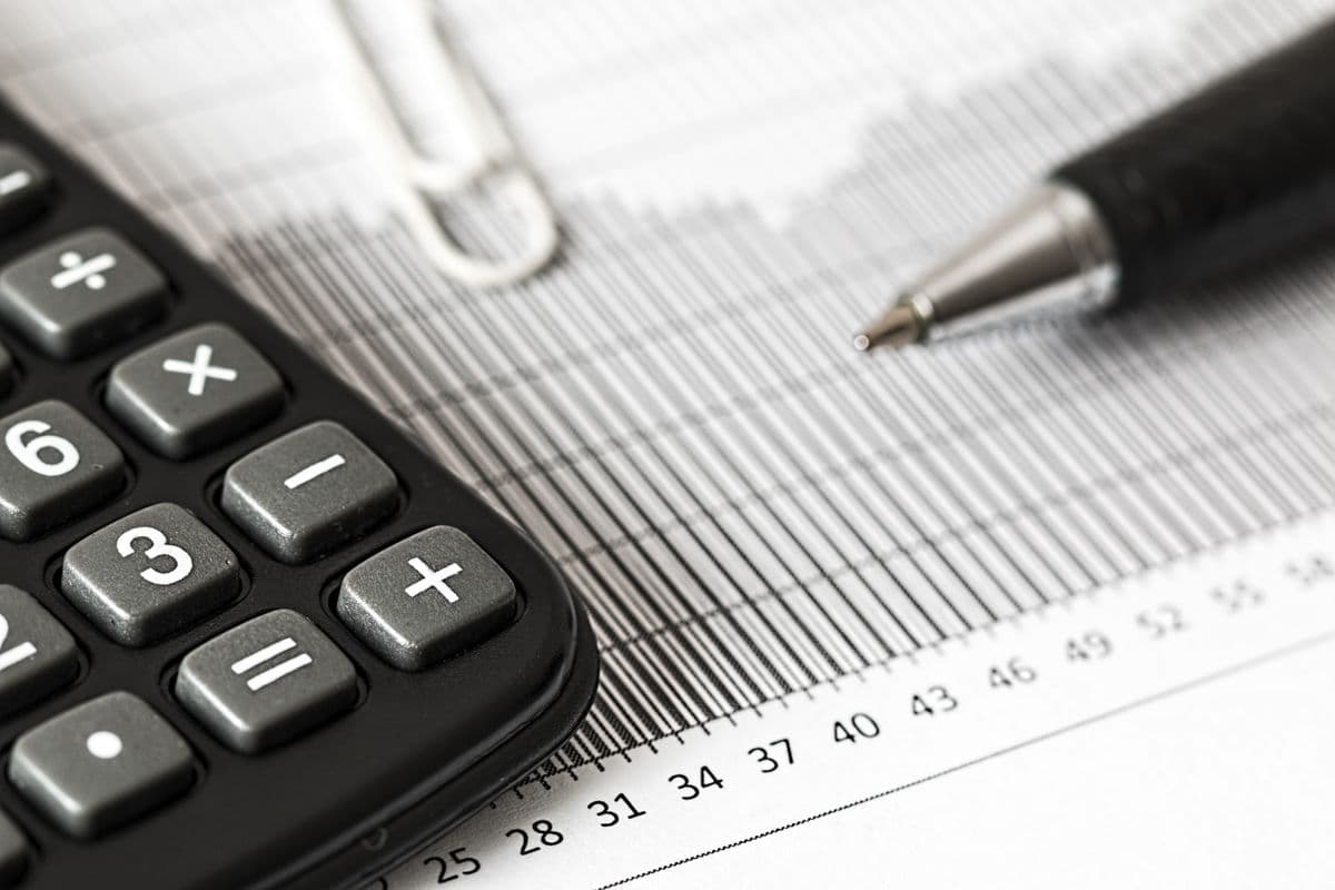 Calculadora e caneta sobre um relatório financeiro impresso