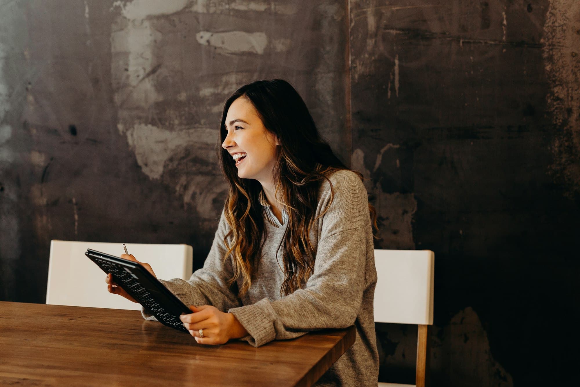 Empreendedora sorrindo enquanto revisa as informações da empresa no tablet
